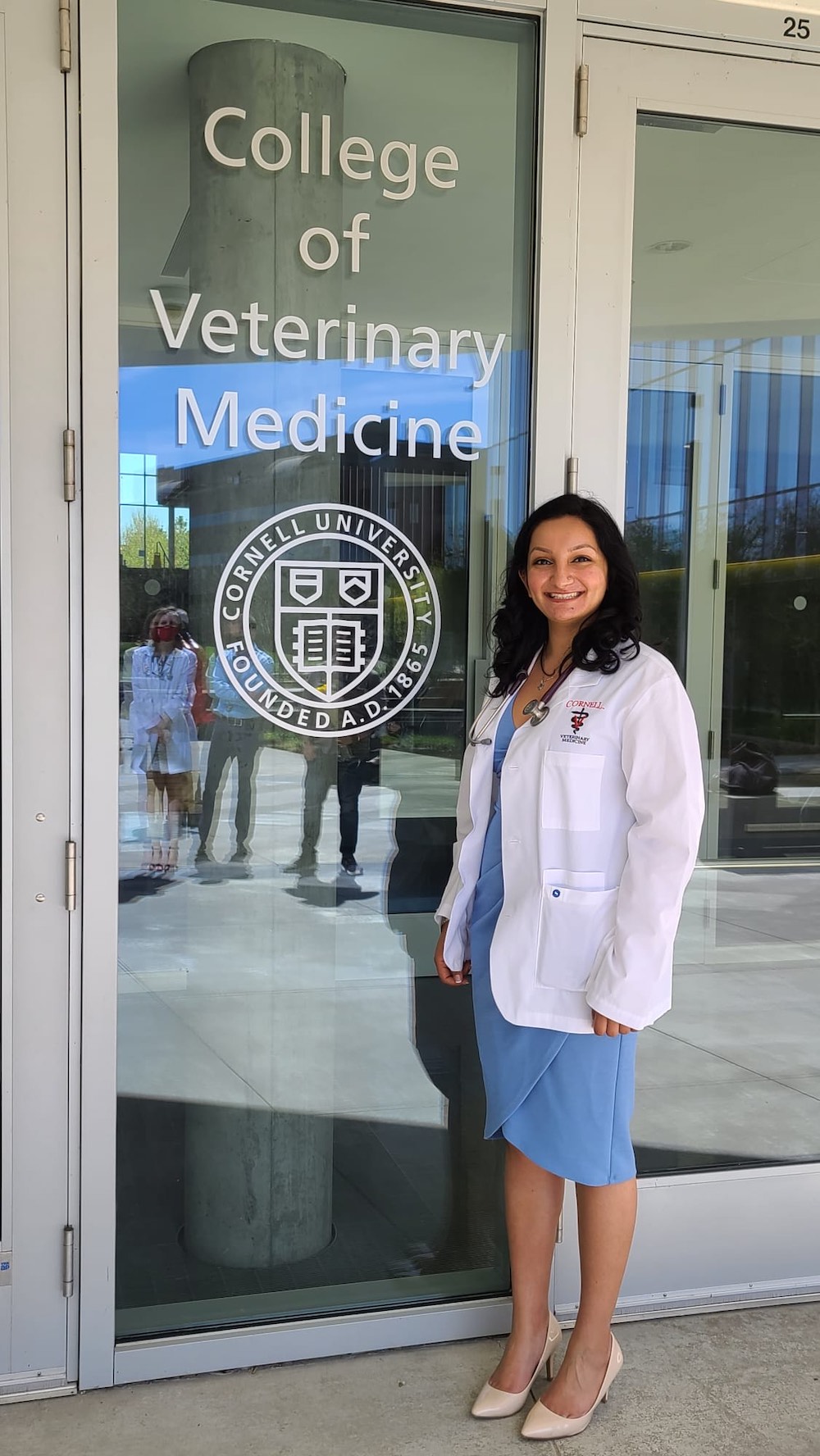 Karuna Katariwala poses next to the CVM entrance in her white coat