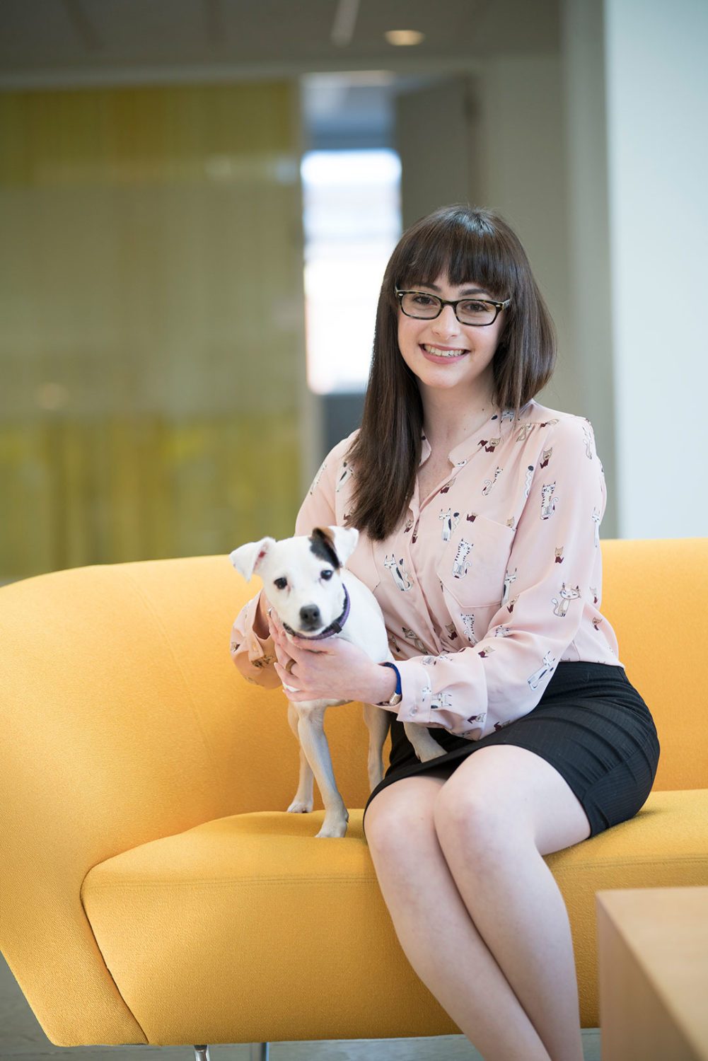 Alexandra Kravitz sitting in the CVM atrium with a small white dog