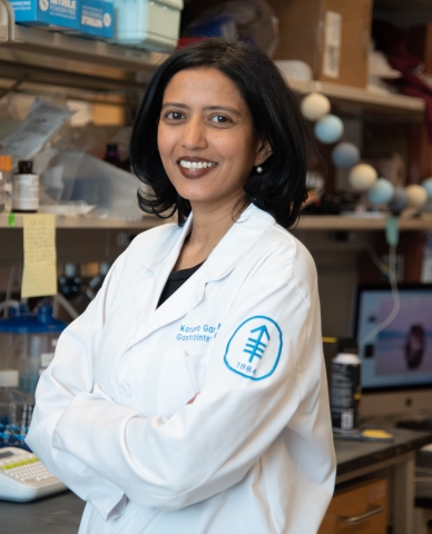 Dr. Karuna Ganesh smiling in a lab 