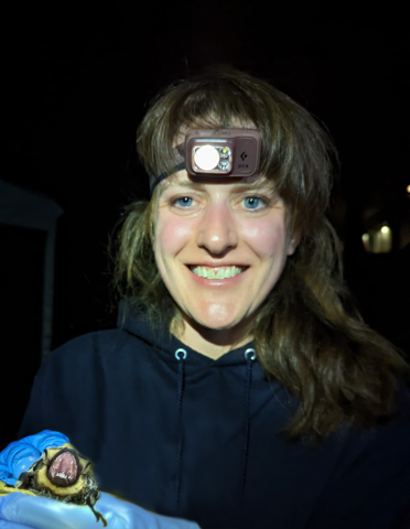 Dr. Andrea Rummel smiling holding a bat 