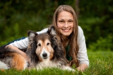 Photo of Jennifer Prieto in a grassy field with her dog.
