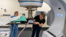 Two technicians position a patient on the linear accelerator