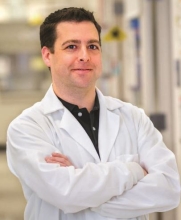 Andrew White wearing a lab coat in the lab.