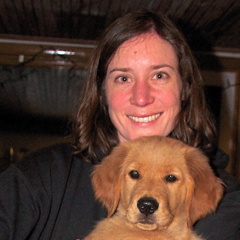 Jess Hayward holds a young golden retriever