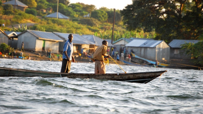 two fisher people standing in a small boat