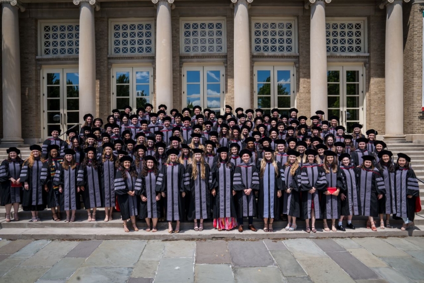 DVM Class of 2024 standing together outside in their hooding regalia.
