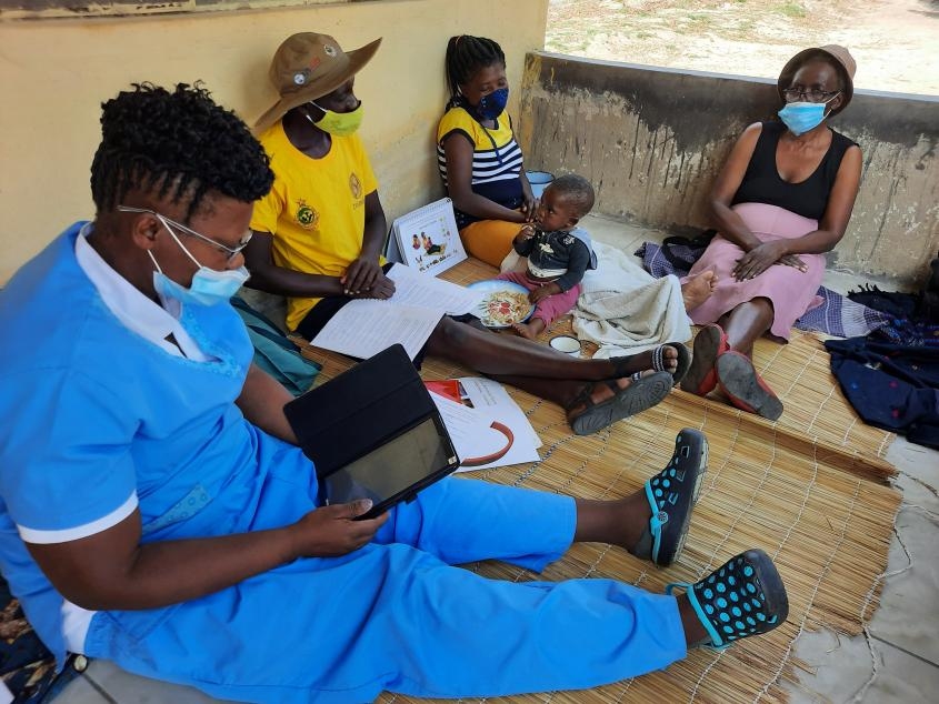 Family in Zimbabwe talking with a public health worker