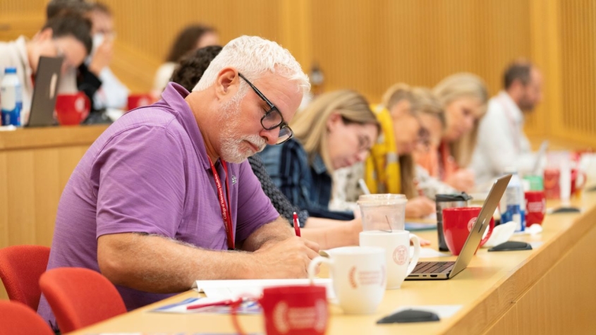 Conference attendees doing work in lecture hall