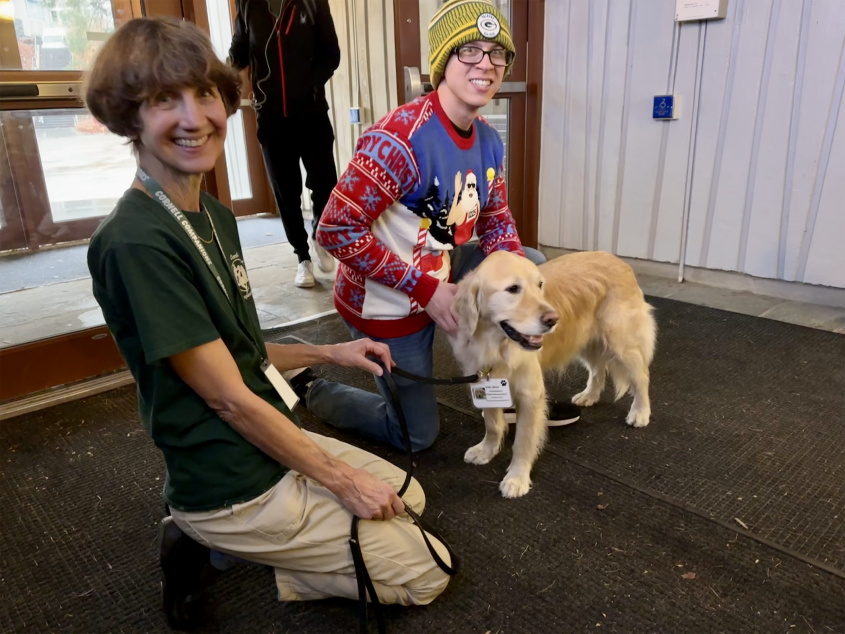 two people with golden retriever