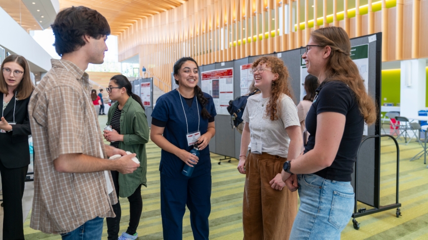 Students chatting and laughing at a poster session