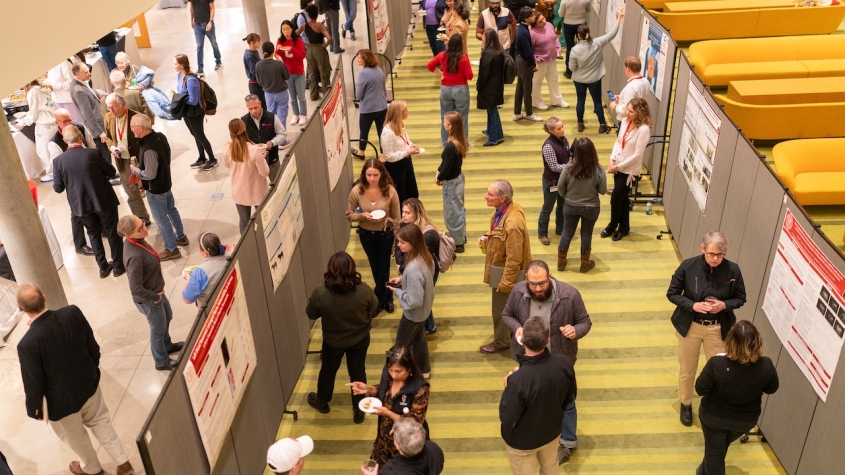 A crowd of attendees in the Schurman Hall atrium for the poster session