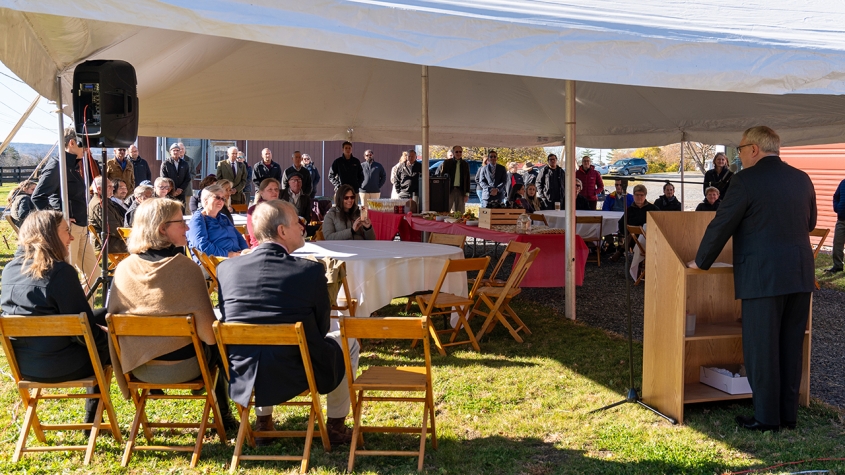 Dean Warnick addressing people at the equine park beneath a canopy on a sunny day