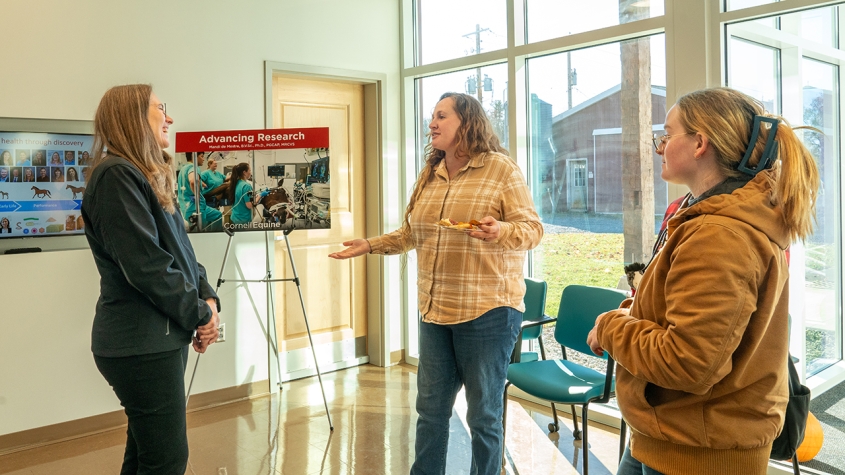 Three people talking within the new equine park building