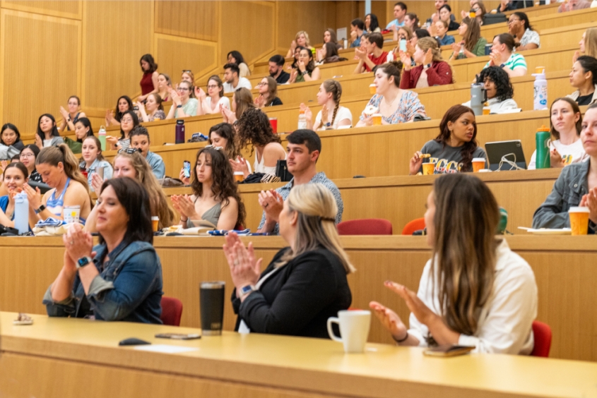 People clapping in a lecture hall