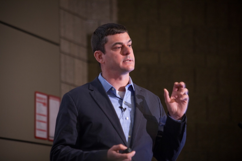 Adam Boyko speaking on a stage