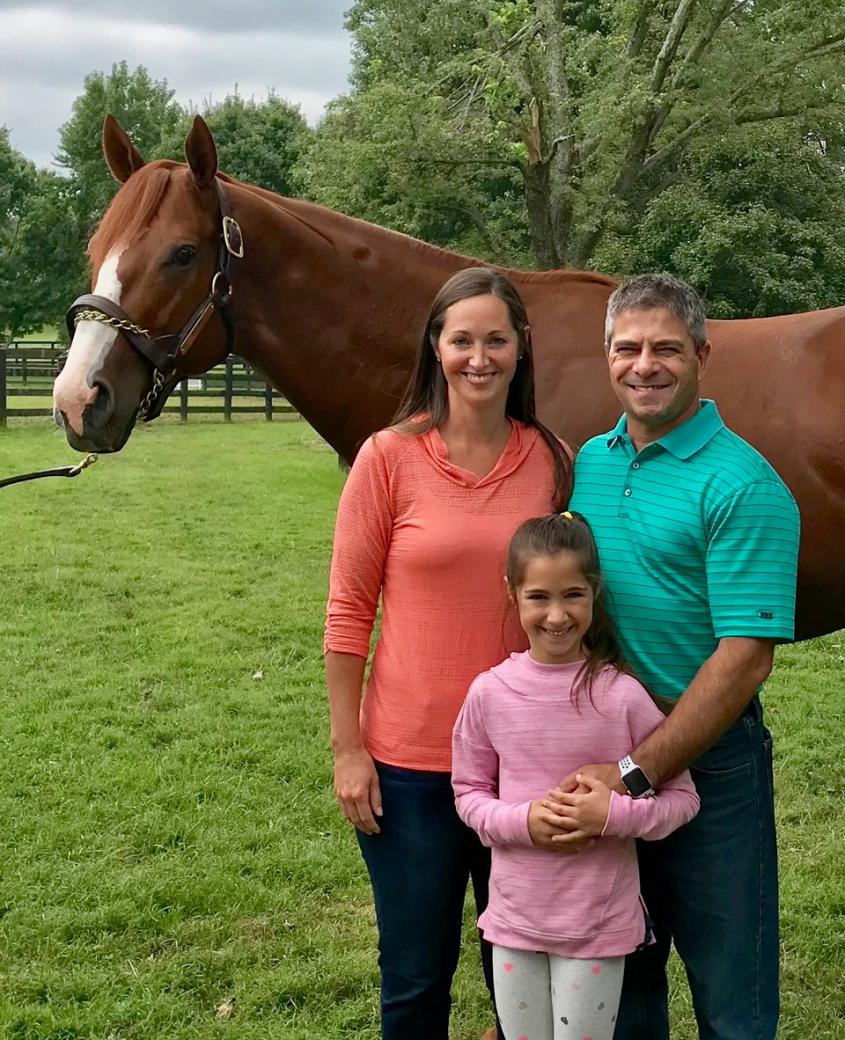 Jorge Colon, his wife and daughter next to a racehorse