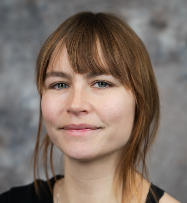 Amandine Gamble in front of a gray background.
