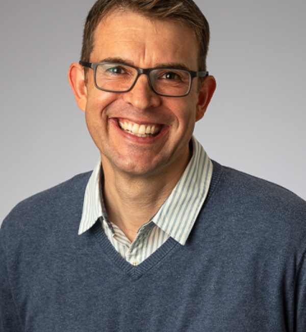 Matthias Wieland wearing a gray sweater and a collared shirt.