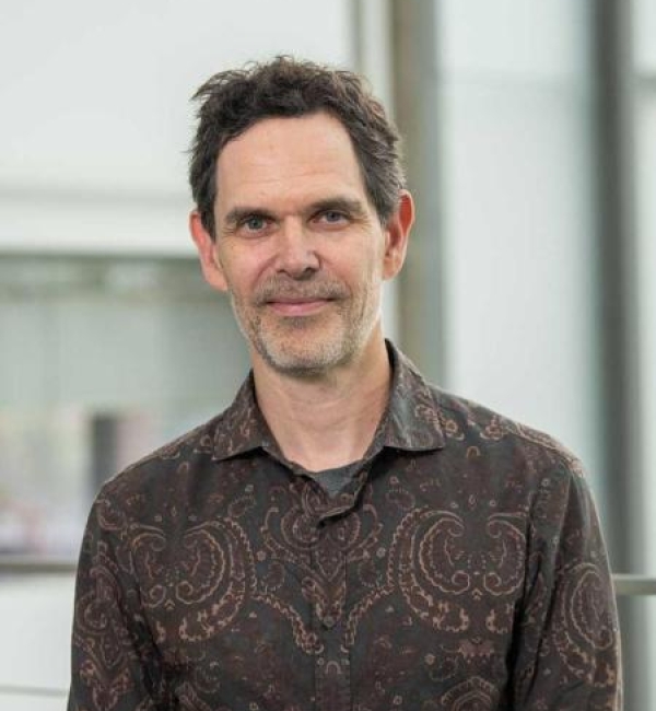 Brian Crane wearing a brown dress shirt with mandala design.