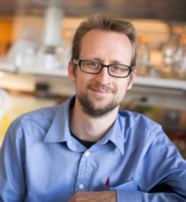 Tobias Doerr in the lab wearing a light blue button up shirt.