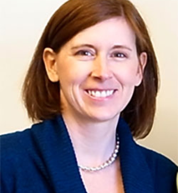 Cynthia Leifer wearing a deep blue blazer and blouse with a pearled necklace along an off-white background.