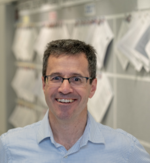 Martin Wiedmann in front of a bulletin board wearing a light blue-collared shirt.