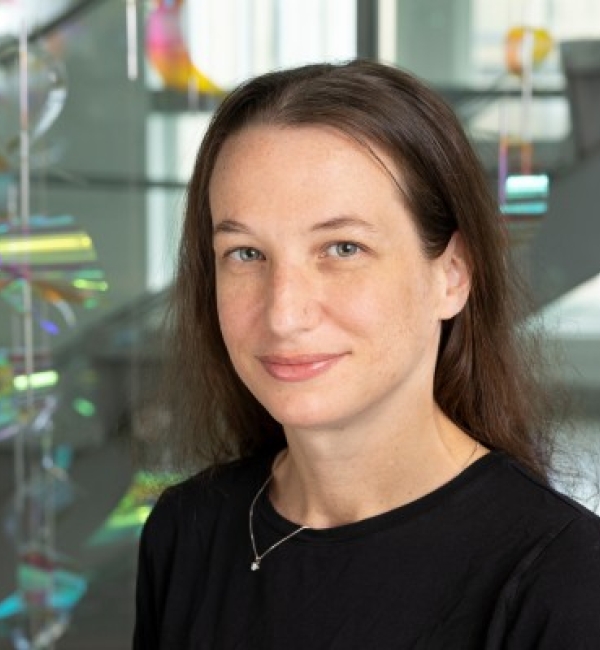 Julia Finklestein wearing a black top in front of the polychromic stringed artwork in MVR.