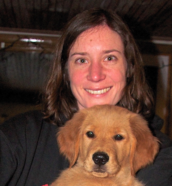 Jess Hayward holds a young golden retriever